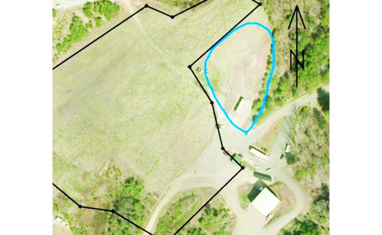 The blue circled area in this aerial photo shows a possible site for a new recycling and household garbage center near the Transfer Station. The dark line represents the boundary of the capped landfill area.