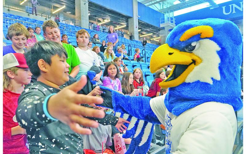 Justin Morales Soriano goes in for a hug with Nigel the Nighthawk, UNG's mascot, while friends (from left) Cooper McKee, Nathan Hester, Maddox Davis and Ethan Richards watch and laugh along.