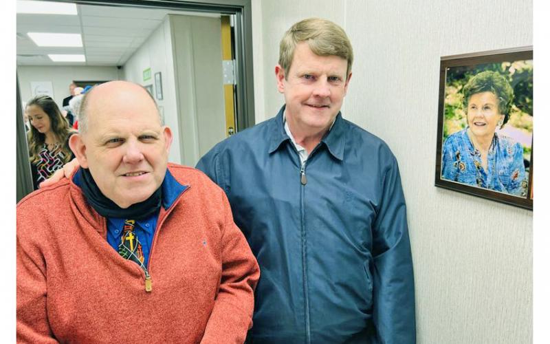 David (left) and Eddie Green stand beside a plaque honoring their late mother, Anne, for whom the new clinic is named. She was one of the free clinic’s most ardent supporters from the beginning, whose idea of holding a tomato sandwich supper became its signature fundraiser each year.