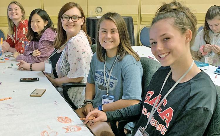 Members of the 2019-2020 LCHS yearbook staff (from right) managing editors Charlotte Cunningham and Olivia Gilleland, photo editor Lacy Gilreath and copy editors Autumn Cleymans and Brianne Anderson hone their yearbook design skills at the Herff Jones Yearbook Expo last July.