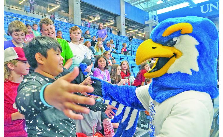 Justin Morales Soriano goes in for a hug with Nigel the Nighthawk, UNG's mascot, while friends (from left) Cooper McKee, Nathan Hester, Maddox Davis and Ethan Richards watch and laugh along.