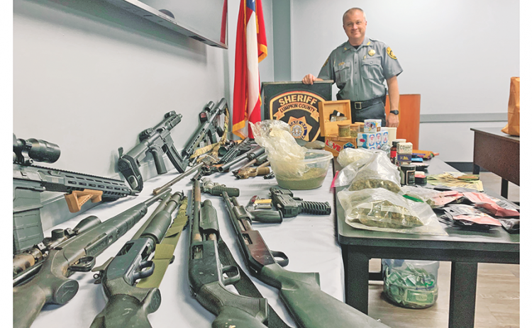 Deputies and drug agents confiscated numerous firearms, a reported three pounds of marijuana, and a stash of cash from a Pecks Road residence last week.