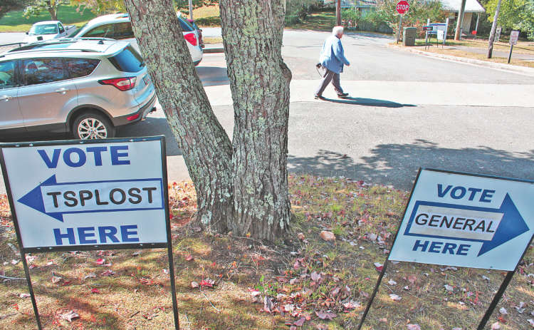 On Friday morning, a determined early voter strides between polling places on Short Street. (Photo by Keith Murden)