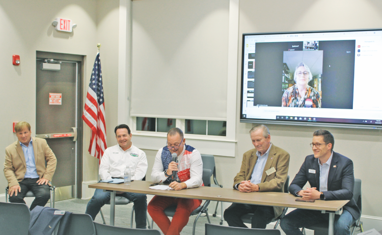 Candidates for Dahlonega City Council participate in a public forum at the local library. Pictured are (from left) current Council members Johnny Ariemma and Lance Bagley, James T. Guy, Tom Gordineer, Dan Brown and appearing via Zoom video, Melanie Dunlap.