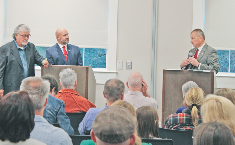 Incumbent Sheriff Stacy Jarrard (right) addresses challenger Matt Cook during last week’s candidate forum as moderator Roger Smith (far left) glances at his notes.