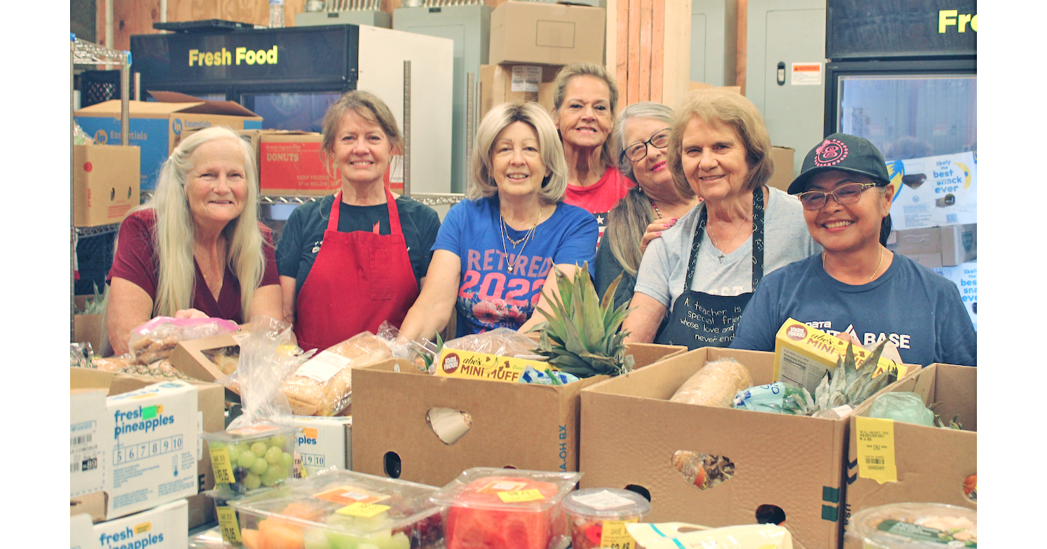 Food bank volunteers (from left) Monica Powell, Elaine Dinsmore, Suzanne Depew, Vickie Foster, Patricia Taylor, Donna Sears and Eugenia Thurmond are all smiles as they prepare boxes for pick-up.