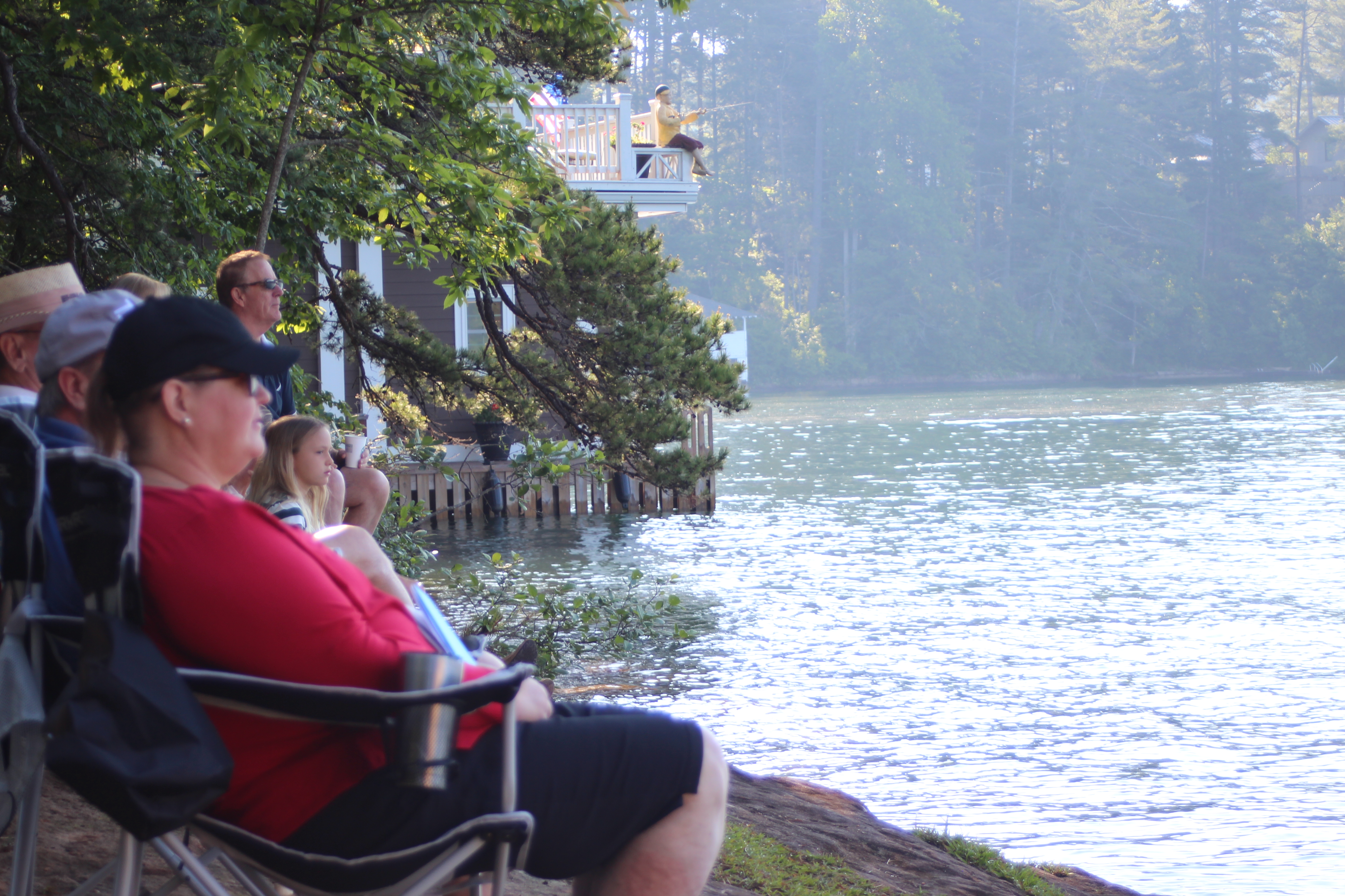 Cheryl Blackburn sits on the shoreline of Lake Rabun for the season's first boat church at Clayton First United Methodist Church. (Photo/Megan Broome)