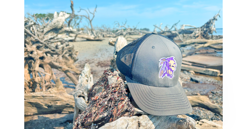 Sports writer Eligha Roper’s Lumpkin County sports cap takes a vacation at Driftwood Beach.