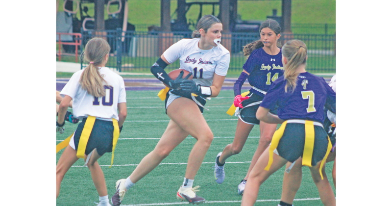 Lumpkin County’s Brooklyn Santiago looks for yardage as Team Purple defenders give chase.