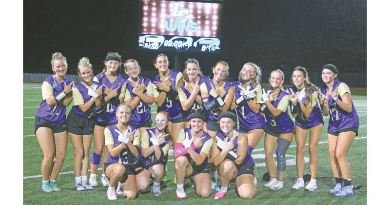 The Lady Indians celebrate the varsity flag football team’s first-ever victory.