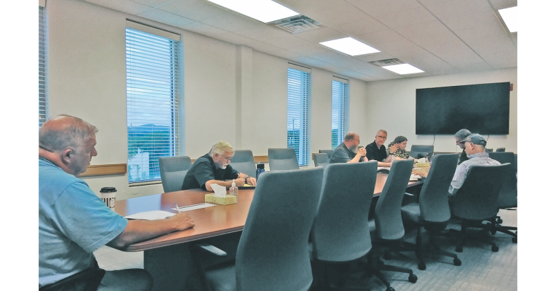 The Lumpkin County Airport Authority (right) considers changes to its hangar lease agreements and the construction of a new fuel farm as two audience members listen in from the opposite end of the table.