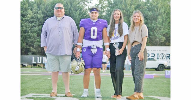 Weston Veater walks onto the field with his family during Senior Night.