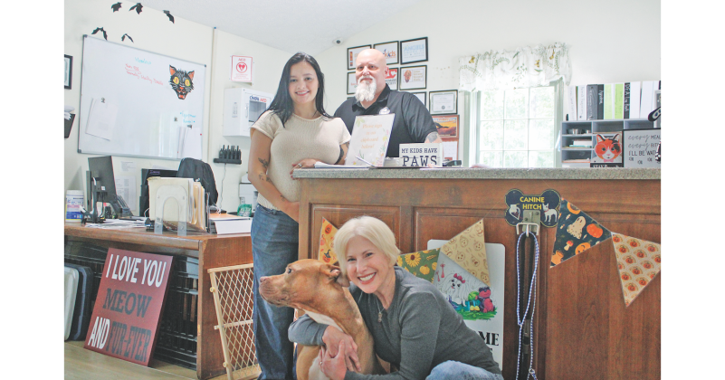 Volunteer Diana Dunetz gives a quick hug to Soda Pop, the honorary Chair Dog of the Run for the Rescues 5K, as Friends of Lumpkin County Shelter Animals President Savana Borchers and Lumpkin County Animal Services Manager Wayne Marshall look on.
