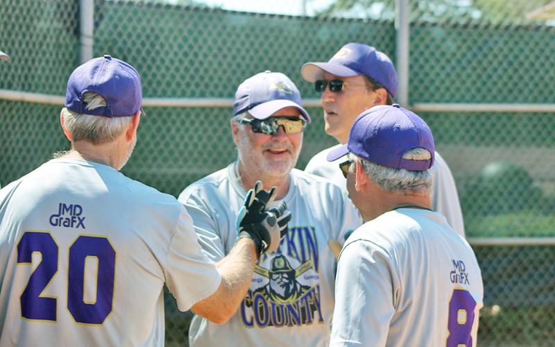 Lumpkin County Miners player/coach John “Da Boss” Daley gets a healthy dose of high-fives after belting a three-run, inside-the-park home run versus the Dahlonega Gold during a Clayton League doubleheader last week.