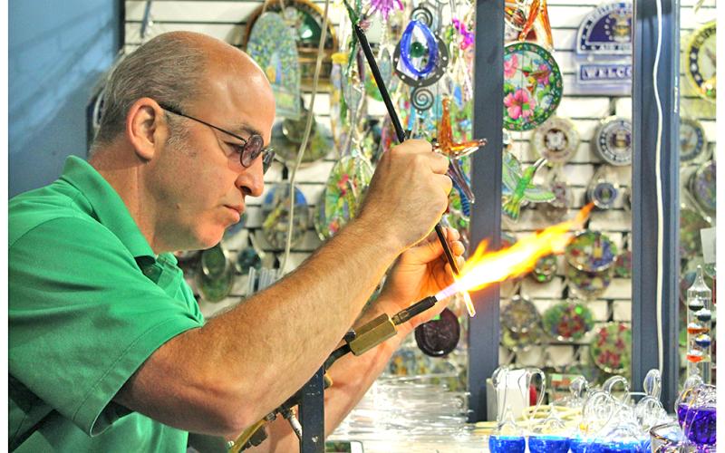 The Glassblowing Shop owner Chris Kennedy, a fourth generation glassblower, works effortlessly to combine two glass rods together for an order of icicle Christmas ornaments. This story is one of many regional features in the new edition of The Mountain Traveler magazine.