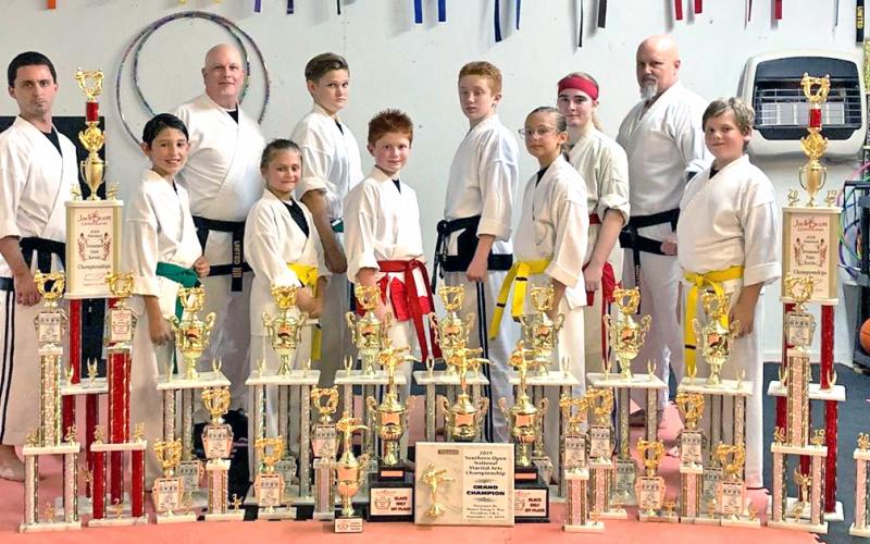 Local karate competitors pictured (from left): Travis Hamner (instructor), Christopher Frausto, Brad Bowelle (chief instructor, owner), Ella Greene, Owen Mondell, Aiden Marshall, Austin Marshall, Lindsey Greene, Alexis Weir, Wayne Marshall (instructor) and Josiah Payne. Not pictured: Jameson Ballard, Nathan Voci, Tyler Voci and Luke Scheinoha.