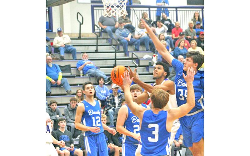 Indians scoring standout Pat Jackson flies through traffic to the basket for two of his 15 points in Lumpkin’s loss to eighth-ranked Banks County at the Longhouse last week.