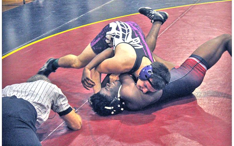 Indians wrestler Jeremiah Holmes gets his opponent on his back for a win by pin during the Trojan Invite at Lassiter High School on Saturday, Dec. 21.