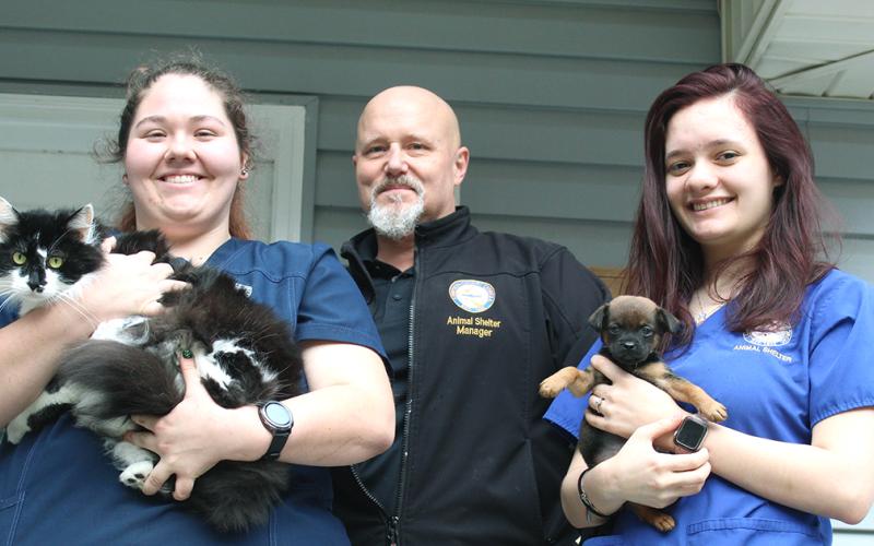 Lumpkin County Animal Shelter staff workers are, from left, Aaron Taylor, holding Slim, Wayne Marshall and Savana Scheidt, holding Pup.