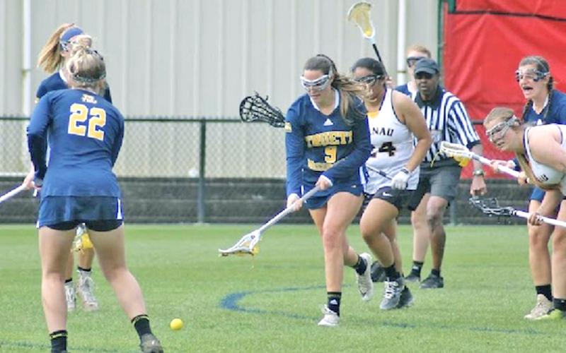 Holly Foster scoops up the ball for the Truett McConnell University Lady Bears. She and her sister Hope have made quite the mark on collegiate lacrosse fields since they learned how to play the game two years ago.