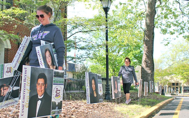 Lumpkin County High School assistant principal Whittney McPherson carries senior signs as she and other LCHS faculty members placed the signs along downtown Dahlonega to honor the Class of 2020.