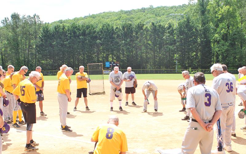 Members of Lumpkin County’s two senior softball teams, the LC Miners and the Dahlonega Gold, take a moment for prayer before playing their first game since last season after the coronavirus pandemic delayed the start of their season. All players were thankful to be back on the diamond after the long hiatus.