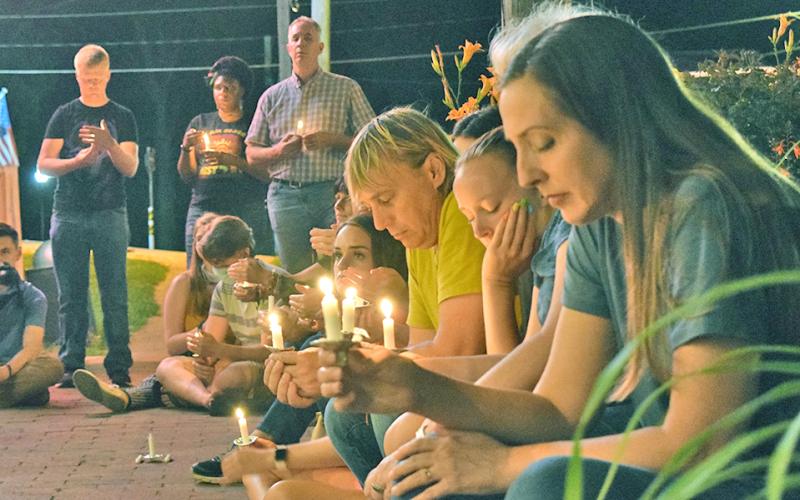ABOVE: A crowd of community members, including Patti Wright (foreground), gathered downtown Sunday evening for a race-related prayer vigil in front of Canopy+Roots.