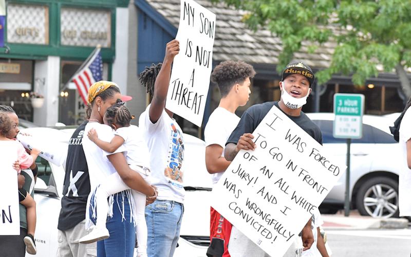 Local resident Antonio Head (far right) leads a rally along with family and friends on the Public Square.