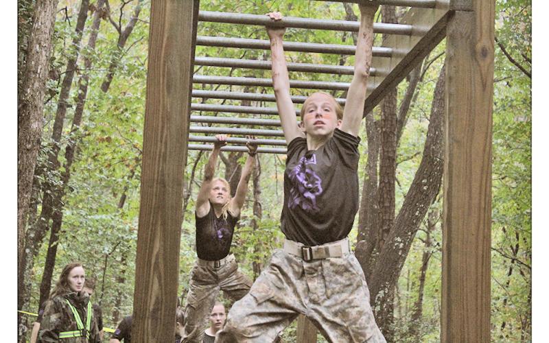 LCHS Raiders Addison Hope (front) and Melia Matkovic climb through the metal bars, testing their strength, endurance and toughness as the bars eat away at their grip with each swing.