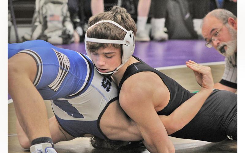 Returning state placer Jack Irwin works to force his opponent flat on his back, resulting in a pin. The junior finished with pins in both matches.