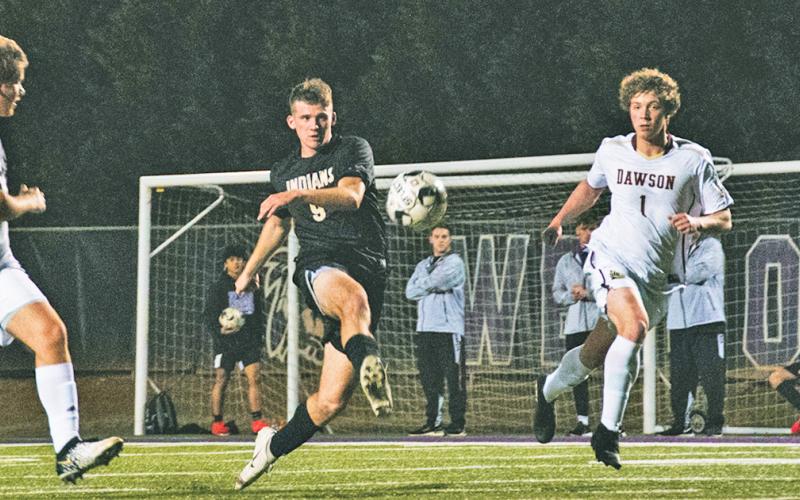 Senior Dylan Bodney sends the ball between multiple Dawson County defenders on the attacking end during the team’s Senior Night victory over the Tigers. Bodney scored one of three goals.