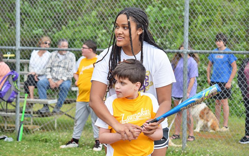 Luca Diamante and Kate Jackson, who await a pitch from Bob Burrell as Susan Burrell (not pictured) coaches from the backstop.