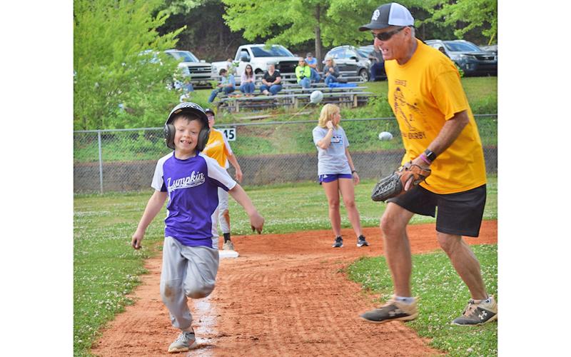 Henley Caldwell, left, is just too fast for the competition, as the young slugger streaks past Bob Burrell and heads for home.