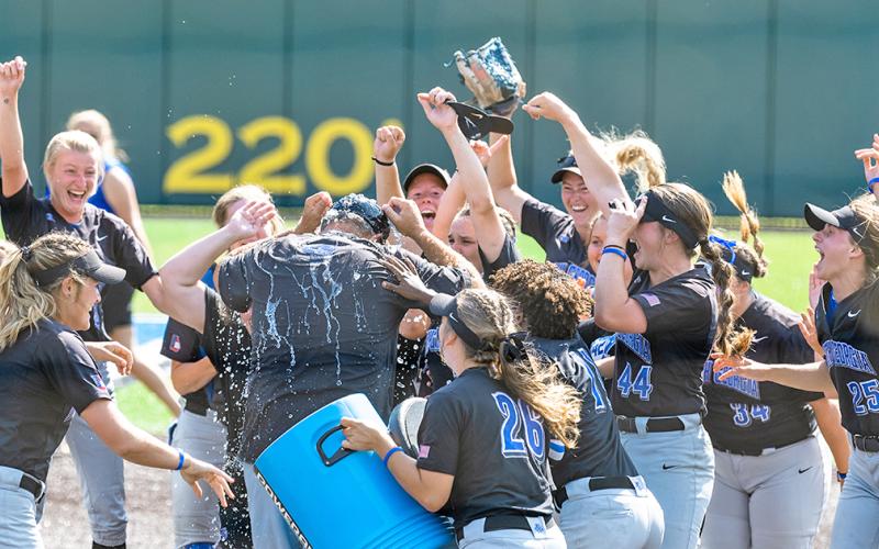 The Nighthawks give head coach Mike Davenport a celebratory dousing after punching their ticket to the NCAA Division II Softball Championship in Denver with back-to-back wins over Lincoln Memorial University on Saturday.
