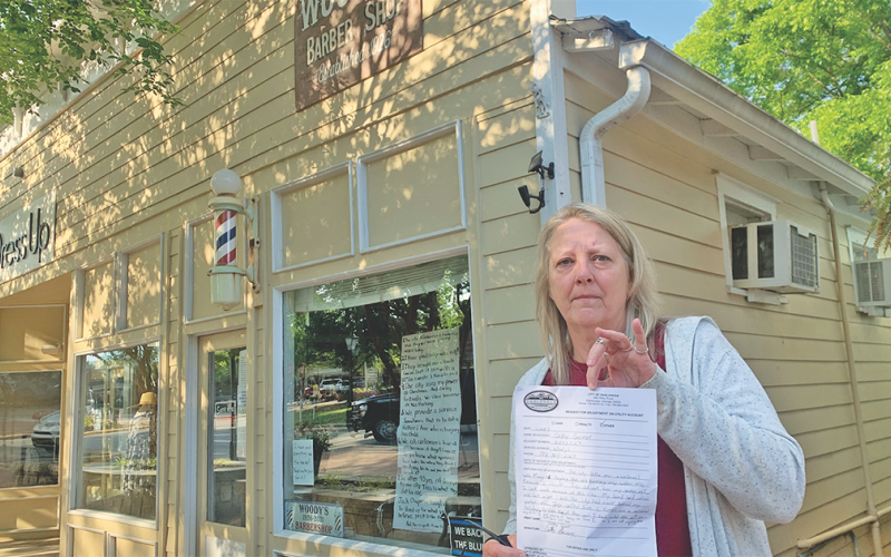 Woody’s Barber Shop owner Cathy Garner paid her garbage bill Tuesday morning, but wasn't happy about the mandatory fee.