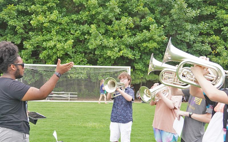 One of last season’s Drum Majors, Najja Hughey, conducts a group of brass players as they practice their 2021 Halftime Show. Hughey was one of several former band leaders that director Andrew Harwood had come back to help with instruction for this year’s Band Camp.