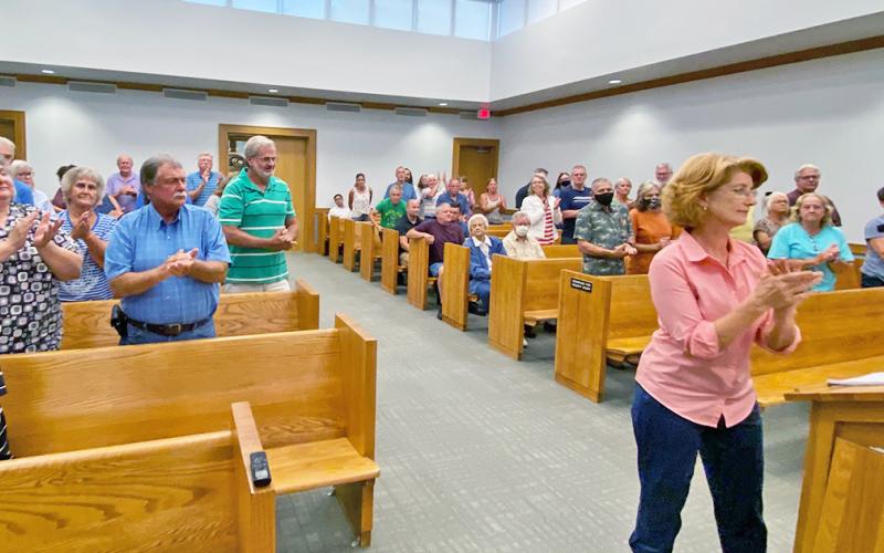 ABOVE: Katherine James (left) who could potentially be a next-door neighbor to the DiVine Village development if it goes through, speaks to the Planning Board on behalf of a  room of concerned Frogtown residents.
