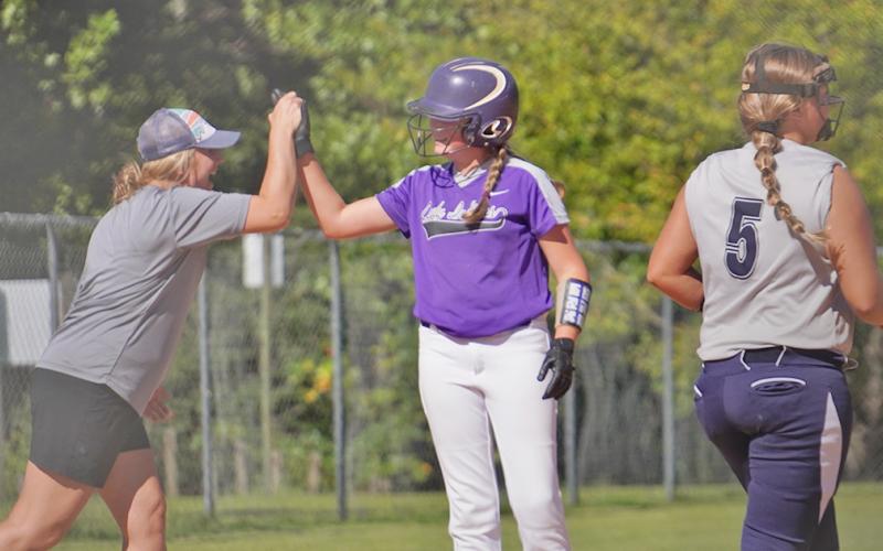 Head coach Brooke Grindle celebrates with Riley Dyer after she knocked in two runs with a double before advancing to third to give the Indians a 6-2 lead in the first inning.