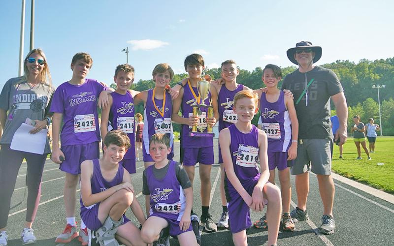 The LCMS boys cross country team celebrates with the trophy after claiming their second first-place finish of the season with five runners finishing in the top 15 of the event.