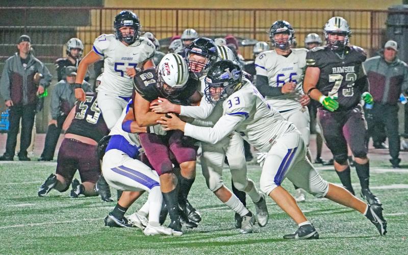 Andrew Adams (right) helps a group of Indians defenders take down the ball carrier to limit the damage in Friday night’s game against Dawson County. The Tigers outpaced en route to a 42-8 win over Lumpkin, giving up three touchdowns to the Tigers running back.