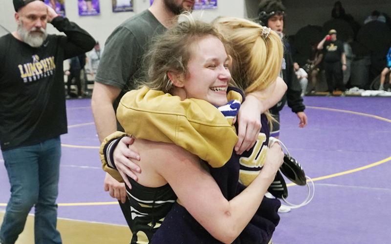 Lumpkin wrestler Chloe Carver meets her sister Kylie with a big hug after clinching a berth at the State tournament. Carver, a senior, is making her long-awaited first appearance at the State tournament after injury held her out last year.