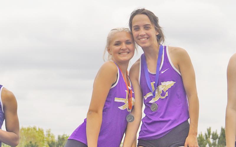 Lumpkin leapers Kaylee Caldwell (left) and Mercades Housman pose atop the podium after securing first and second place in the triple jump event at the region championship competition. Housman took first in both triple jump and long jump with Caldwell a close second in both events.