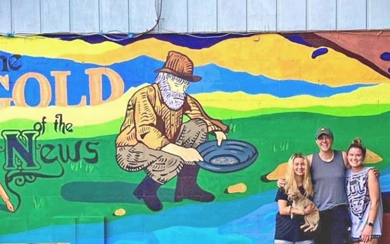 The muralists, from left, Whitney Little, Peyton Hollie, Megan Carlile said “it’s a pop of color the town needed.” (Photo courtesy of Chris Worick)