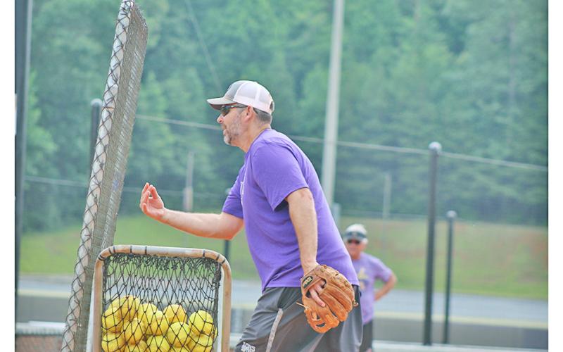 Head coach Joseph Jones delivers batting practice to his players during the final practice before the GHSA Dead Week.