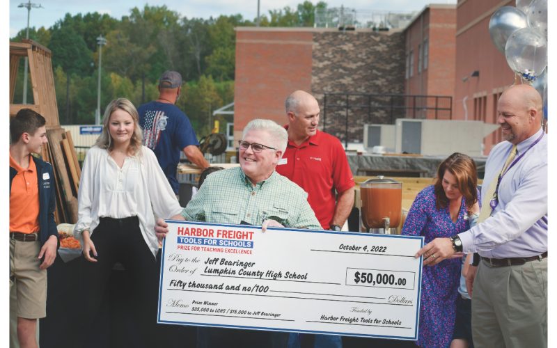 Lumpkin County High School teacher Jeff Bearinger receives a large $50,000 check from Principal Billy Kirk and Harbor Freight Regional Manager Lauren Gomez.