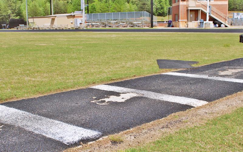 The pole vault approach, situated in the middle of the LCHS track, currently has several large divots that coaches have to cover with rubber scraps for athletes' safety.
