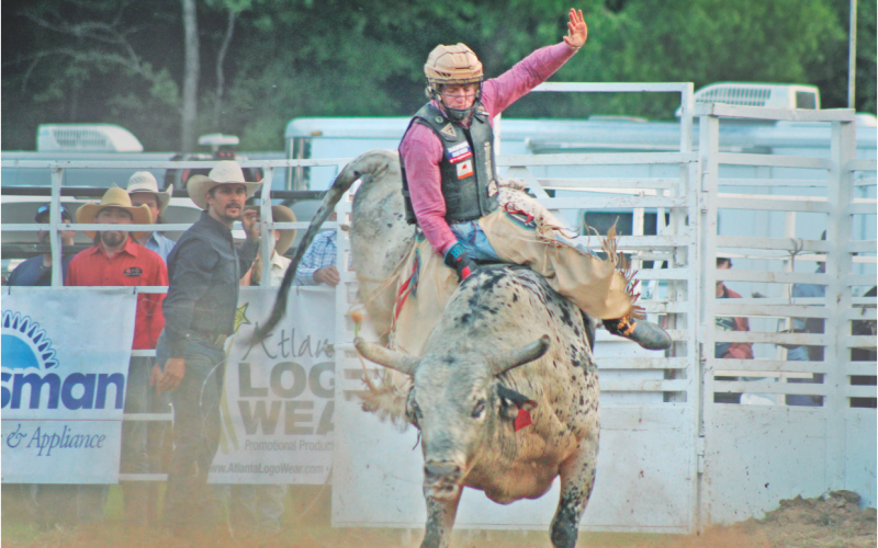 Cole Devlin bravely attempts to stay on the saddle in the bull riding competition during the Mountain Top Rodeo at the R-Ranch.