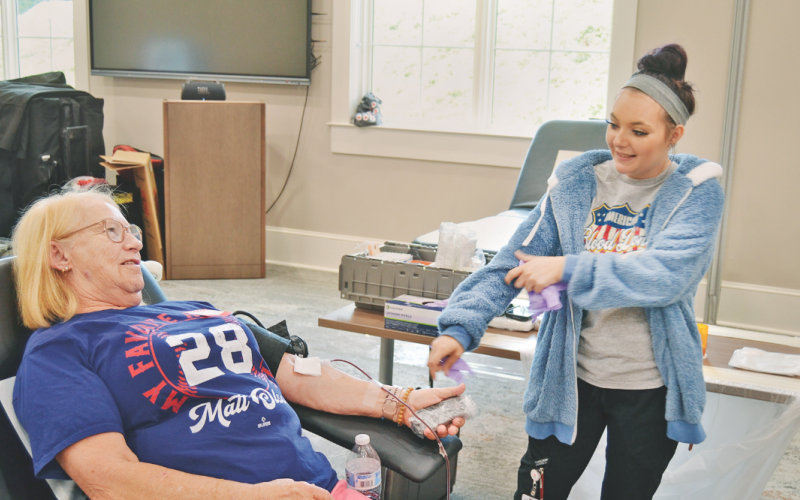 Reba Rider is ready to donate blood at the Lumpkin County Library under the watch of Alyssia Zoller.