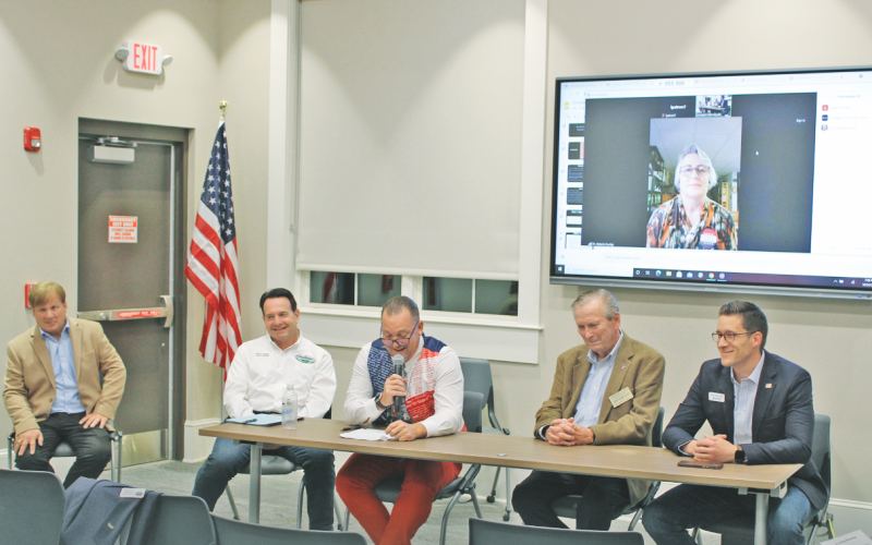 Candidates for Dahlonega City Council participate in a public forum at the local library. Pictured are (from left) current Council members Johnny Ariemma and Lance Bagley, James T. Guy, Tom Gordineer, Dan Brown and appearing via Zoom video, Melanie Dunlap.