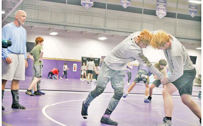 Coach Sean Hage watches wrestlers Austin Marshall and Jacob Pricer to make sure they get the most of their training ahead of the upcoming season.